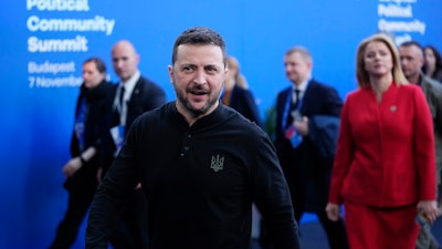 Ukraine's President Volodymyr Zelenskyy, center, and Latvia's Prime Minister Evika Silina, right, arrive for the European Political Community (EPC) Summit at the Puskas Arena in Budapest, Hungary, Thursday, Nov. 7, 2024.