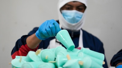 A worker packages popsicles at an artisanal factory in Salcedo, Ecuador, Nov. 28, 2024.