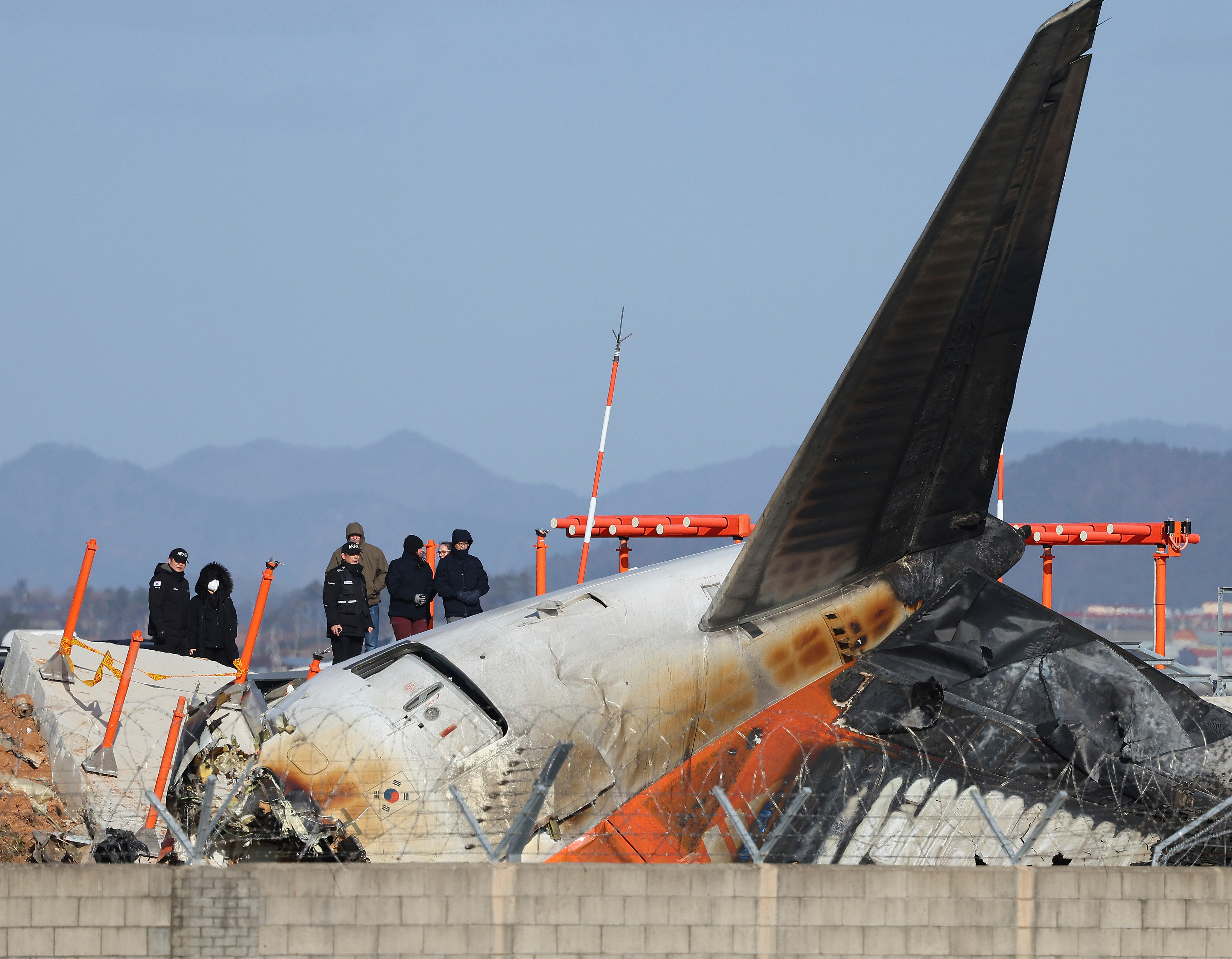 Experts from the U.S. National Transportation Safety Board (NTSB) and joint investigation team between the U.S. and South Korea check the site of a plane crash at Muan International Airport in Muan, South Korea, Tuesday, Dec. 31, 2024.