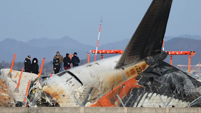 Experts from the U.S. National Transportation Safety Board (NTSB) and joint investigation team between the U.S. and South Korea check the site of a plane crash at Muan International Airport in Muan, South Korea, Tuesday, Dec. 31, 2024.
