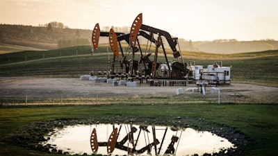 Pumpjacks draw out oil and gas from well heads as wildfire smoke hangs in the air near Calgary, Alberta, May 12, 2024.