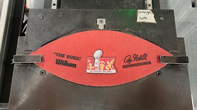 A part of a football for the upcoming Super Bowl matchup between the Philadelphia Eagles and the Kansas City Chiefs sits on a machine at the Wilson Sporting Goods football factory, Monday, January 27, 2025, in Ada, Ohio.