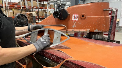 An employee uses a machine that cuts the material into a shape of a football for the upcoming Super Bowl matchup between the Philadelphia Eagles and the Kansas City Chiefs at the Wilson Sporting Goods football factory, Monday, January 27, 2025, in Ada, Ohio.
