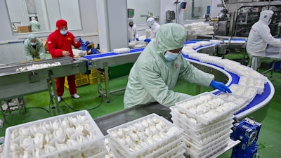 Workers pack dumplings at a production line at a food factory in Suqian city in east China's Jiangsu province on Jan. 21, 2025.