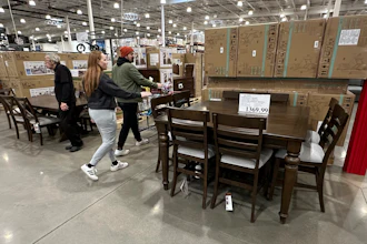 Shoppers pass by a dining room set on display in a Costco warehouse Thursday, Jan. 23, 2025, in Sheridan, Colo.