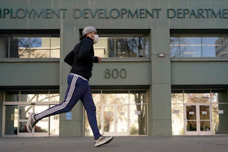 In this Dec. 18, 2020, file photo a runner passes the office of the California Employment Development Department in Sacramento, Calif.