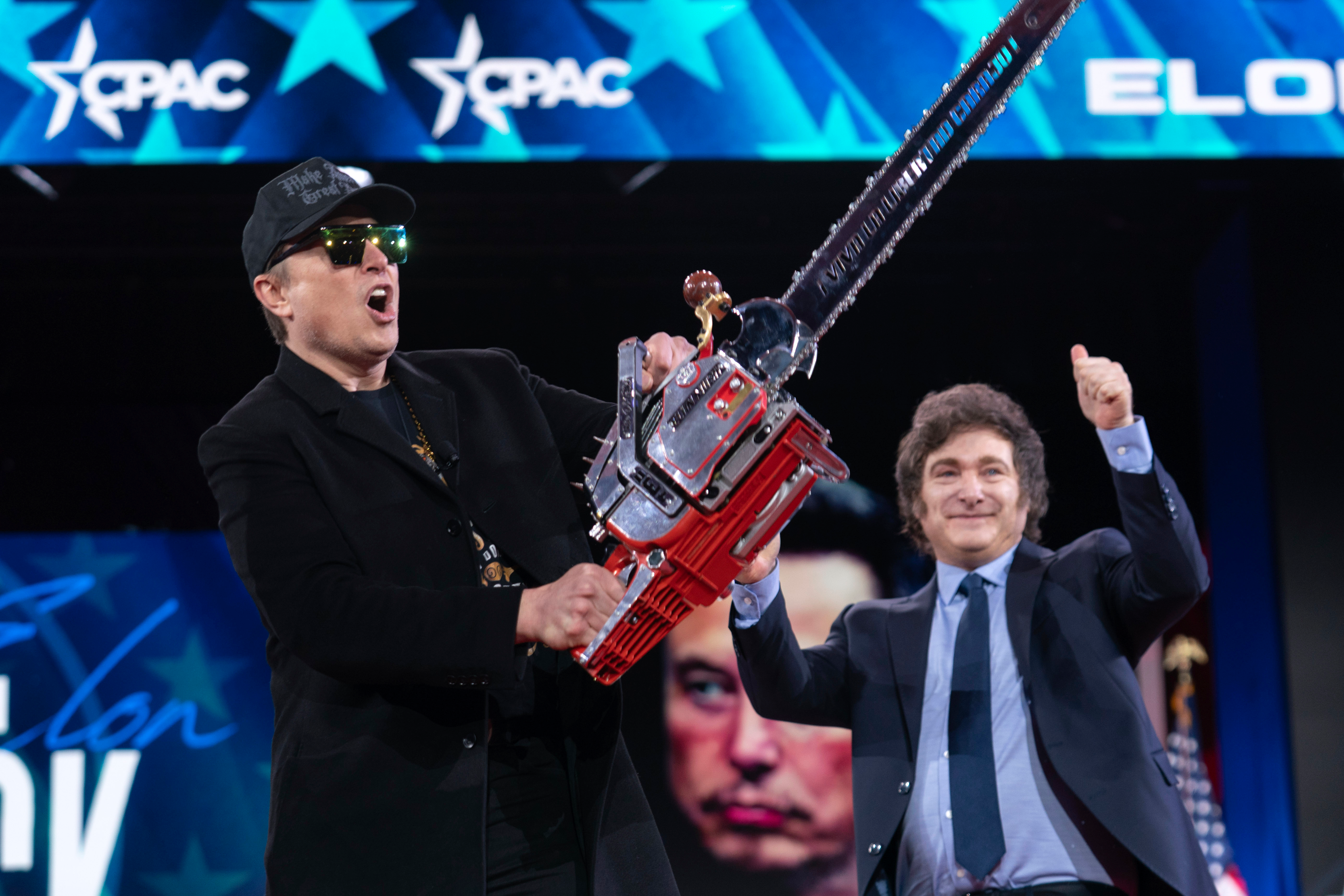 Elon Musk, left, receives a chainsaw from Argentina's President Javier Milei as they arrive speaks at the Conservative Political Action Conference, CPAC, at the Gaylord National Resort & Convention Center, Thursday, Feb. 20, 2025, in Oxon Hill, Md.