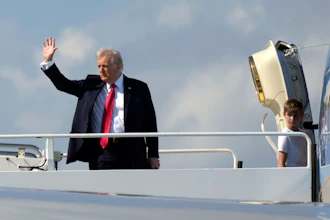President Donald Trump, left, waves as he boards Air Force One with grandson Theodore, Ivanka Trump's son, at Palm Beach International Airport in West Palm Beach, Fla., Sunday, Feb. 9, 2025.