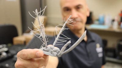 Purdue professor Pablo Zavattieri holds a 3D-printed mosquito head.