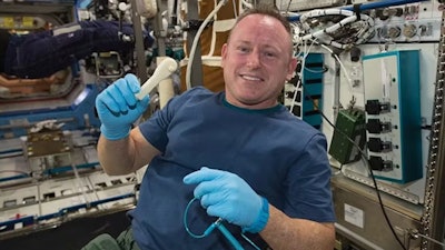 NASA astronaut Barry Wilmore holds a 3D-printed wrench made aboard the International Space Station.