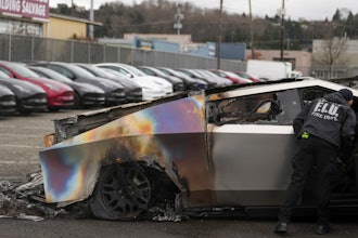 A member of the Seattle Fire Department inspects a burned Tesla Cybertruck at a Tesla lot in Seattle, Monday, March 10, 2025.
