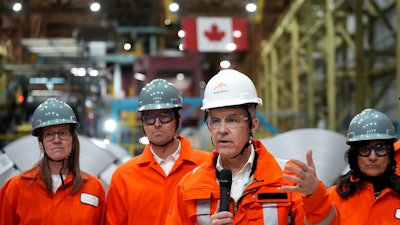 Canadian Prime Minister designate Mark Carney, second right, speaks to steel workers after touring the ArcelorMittal Dofasco steel plant in Hamilton, Ont., on Wednesday, March 12, 2025.