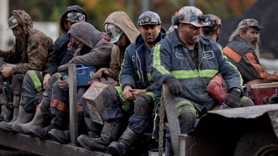 In this Oct. 15, 2014 photo, coal miners return on a buggy after working a shift underground at the Perkins Branch Coal Mine in Cumberland, Ky.