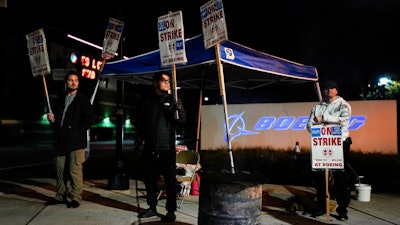 From left, Boeing employees Vance Meyring, Josue Ramirez and Joseph Mellon work the picket line after union members voted to reject a new contract offer from the company, Wednesday, Oct. 23, 2024, outside Boeing facilities in Renton, Wash.