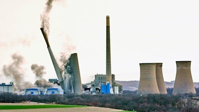The smokestacks of the former coal-fired Homer City Generating Station crumble in a planned demolition to make way for a new natural gas-fired power plant in Homer City, Pa., March 22, 2025.