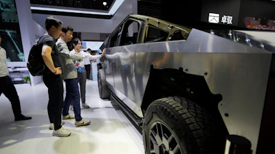 Visitors look at a bare-bones version of Tesla's Cybertruck with devices from AOD Technology, which makes domain control units that process various commands such as opening doors and controlling running boards on SUVs, displayed at the Shanghai auto show on Thursday, April 24, 2025.
