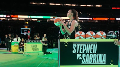 New York Liberty guard Sabrina Ionescu shoots during a competition against Golden State Warriors' Stephen Curry at the NBA basketball All-Star weekend, Feb. 17, 2024, in Indianapolis.