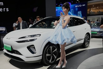A model poses near the Sea Lion 06 DM-i model from BYD at the Shanghai auto show on Wednesday, April 23, 2025.