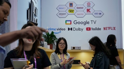 Sales rep promote projectors at the 137th Canton Fair in Guangzhou in southern China's Guangdong province on Tuesday, April 15, 2025.