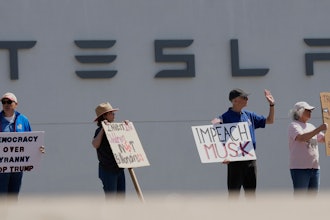 Demonstrators protest against Elon Musk and Department of Government Efficiency cuts outside a Tesla dealership, Saturday, April 12, 2025, in Kansas City, Mo.