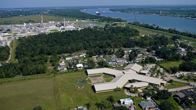 The Fifth Ward Elementary School and residential neighborhoods sit near the Denka Performance Elastomer Plant, back left, in Reserve, La., Sept. 23, 2022.