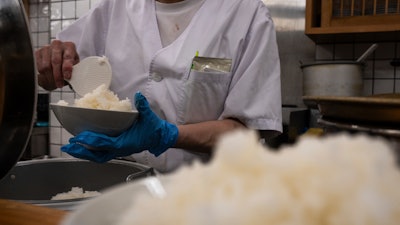 An employee prepares a bowl of rice at a restaurant in Tokyo, Thursday, May 22, 2025.