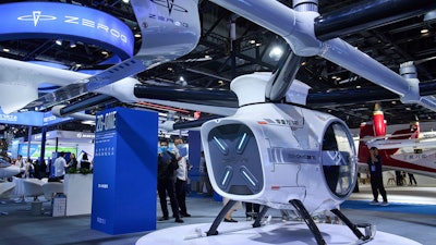 Visitors tour the ZEROG booth showcasing it ZG-ONE, a two-seated eVTOL multicopter aircraft with its autonomous piloting at the 3rd Exhibition of Technology and Education in Civil Aviation as China promoting the low-altitude economy, in Beijing, Tuesday, May 27, 2025.