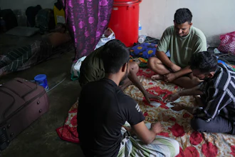 Bangladeshi migrant workers play cards in a dormitory in Klang, Malaysia, Friday, Jan. 24, 2025.