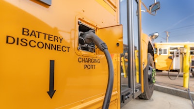 An electric school bus being charged.