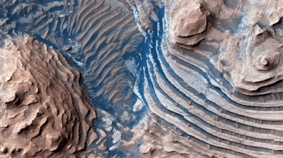 Layered sedimentary rocks exposed within the craters of Arabia Terra, Mars, recording ancient surface processes. Photo from the Mars Reconnaissance Orbiter High Resolution Imaging Science Experiment.