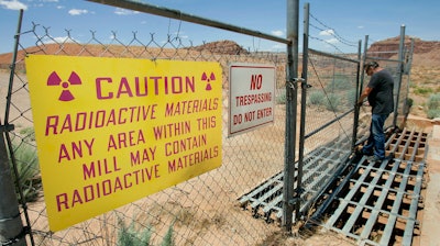 U.S. Energy Corp. resident project manager Daryl Winters locks the gate, on July 12, 2006, at the Shootaring Mill north of Ticaboo, Utah.