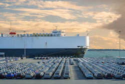 A large auto carrier ship sits at a port. Known as RO-RO vessels, these types of carriers can contain thousands of vehicles.