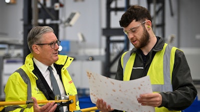 Britain's Prime Minister Keir Starmer, left, speaks to a member of staff during a visit to the BAE Systems'Govan facility, in Glasgow, Scotland, Monday June 2, 2025.