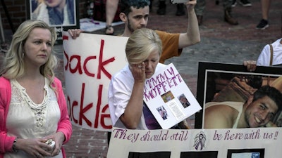 Protesters who have lost love ones to the opioid crisis protest outside a courthouse in Boston, Aug. 2, 2019, where a judge heard arguments in a lawsuit against Purdue Pharma.