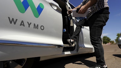 A Waymo minivan arrives to pick up passengers for an autonomous vehicle ride, April 7, 2021, in Mesa, Ariz.