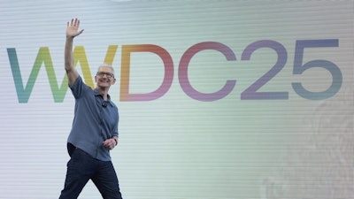 Apple CEO Tim Cook waves to attendees during an event on the Apple campus in Cupertino, Calif., Monday, June 9, 2025.