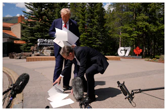 President Donald Trump drops papers as he meets with Britain's Prime Minister Keir Starmer on the sidelines of the G7 Summit, Monday, June 16, 2025, in Kananaskis, Canada.