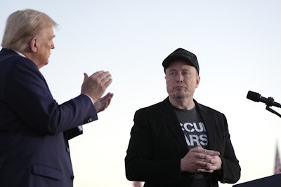 Republican presidential nominee former President Donald Trump, left, claps as Tesla and SpaceX CEO Elon Musk prepares to depart after a campaign event at the Butler Farm Show on Oct. 5, 2024, in Butler, Pa.