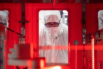 An employee monitors a wafer transfer at one of Texas Instruments’ 300mm semiconductor fabs in Sherman, Texas, SM1.
