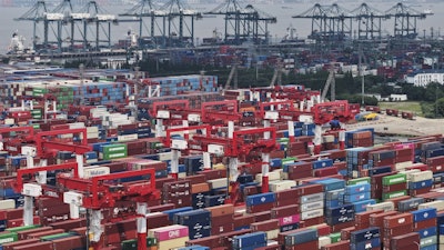 Trucks loaded with container move through a container terminal port in Shanghai, China Monday, June 9, 2025.