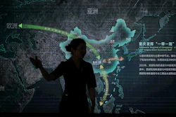 A worker walks by a display board showing the Chongqing Railway Hub for the One Belt One Road project, at the Chongqing Railway Container Terminal Station in southwest China's Chongqing Municipality on Tuesday, May 20, 2025.