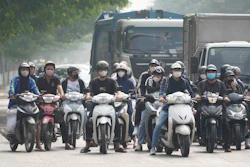 People wearing face masks wait at a traffic signal in Hanoi, Vietnam, on Nov. 14, 2024.