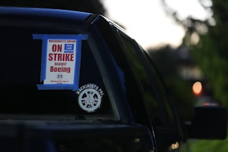 A truck displays a small strike sign in the parking lot of the Aerospace Machinists Union hall as Boeing employees arrive to vote on a new contract offer from the company, Nov. 4, 2024, in Renton, Wash.