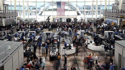 Passengers wait in a security line at Denver International Airport on Feb. 22, 2023.