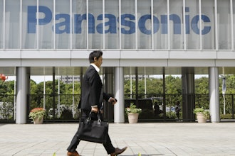 A businessman walks past a corporate logo of Japanese electronics maker Panasonic Corp. at Panasonic Center in Tokyo, Japan, Sept. 10, 2009.