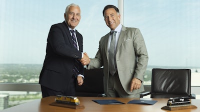 In this photo provided by Union Pacific shows from left, Union Pacific CEO Jim Vena shakes hands with Norfolk Southern CEO Mark George at the meeting where both men signed the agreement to merge the two railroads they lead to create the first transcontinental railroad in the United States on Monday, July 28, 2025 in Omaha, Neb.