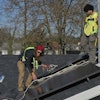 Theodore Tanczuk, left, and Brayan Santos, of solar installer YellowLite, put solar panels on the roof of a home in Lakewood, Ohio, April 17, 2025.