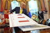 President Trump holds charts as he speaks about the economy in the Oval Office of the White House, Aug. 7, 2025.