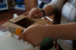 Amanda Follett opens packages at A Sight For Sport Eyes, a brick-and-mortar and e-commerce store for sport goggles, Aug. 20, 2025, in West Linn, Ore.