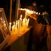 A person lights a candle during a vigil in front of El Teniente copper mine, operated by Codelco, where a cave-in killed six workers, halting operations in Rancagua, Chile, Saturday, Aug. 2, 2025.